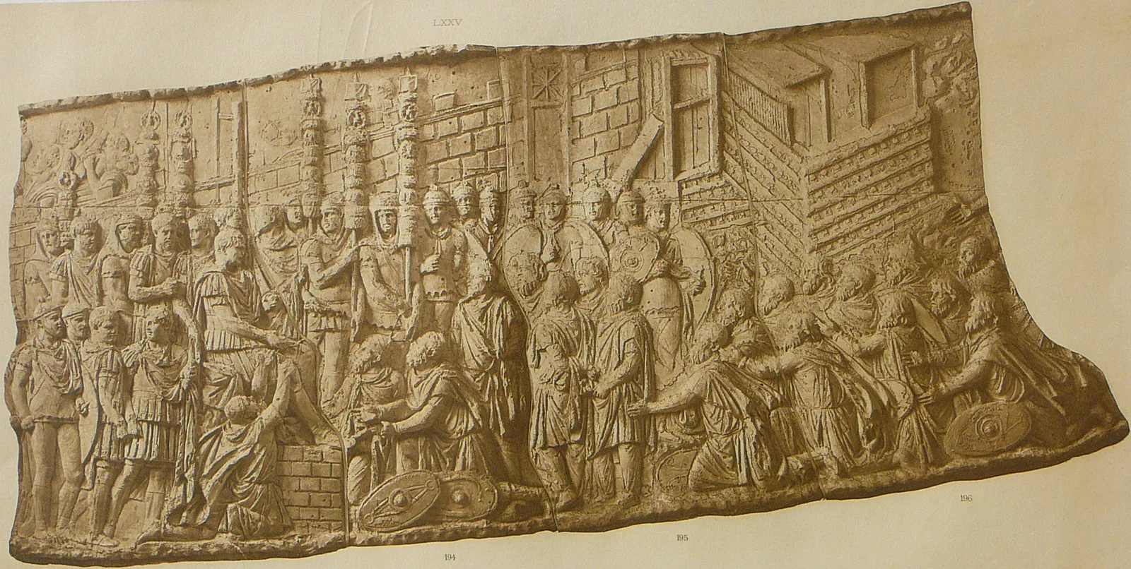 Relief antique en frise montrant des captifs agenouillés devant des soldats romains en armes, porteurs d’enseignes légionnaires, devant les murailles d’une cité prise