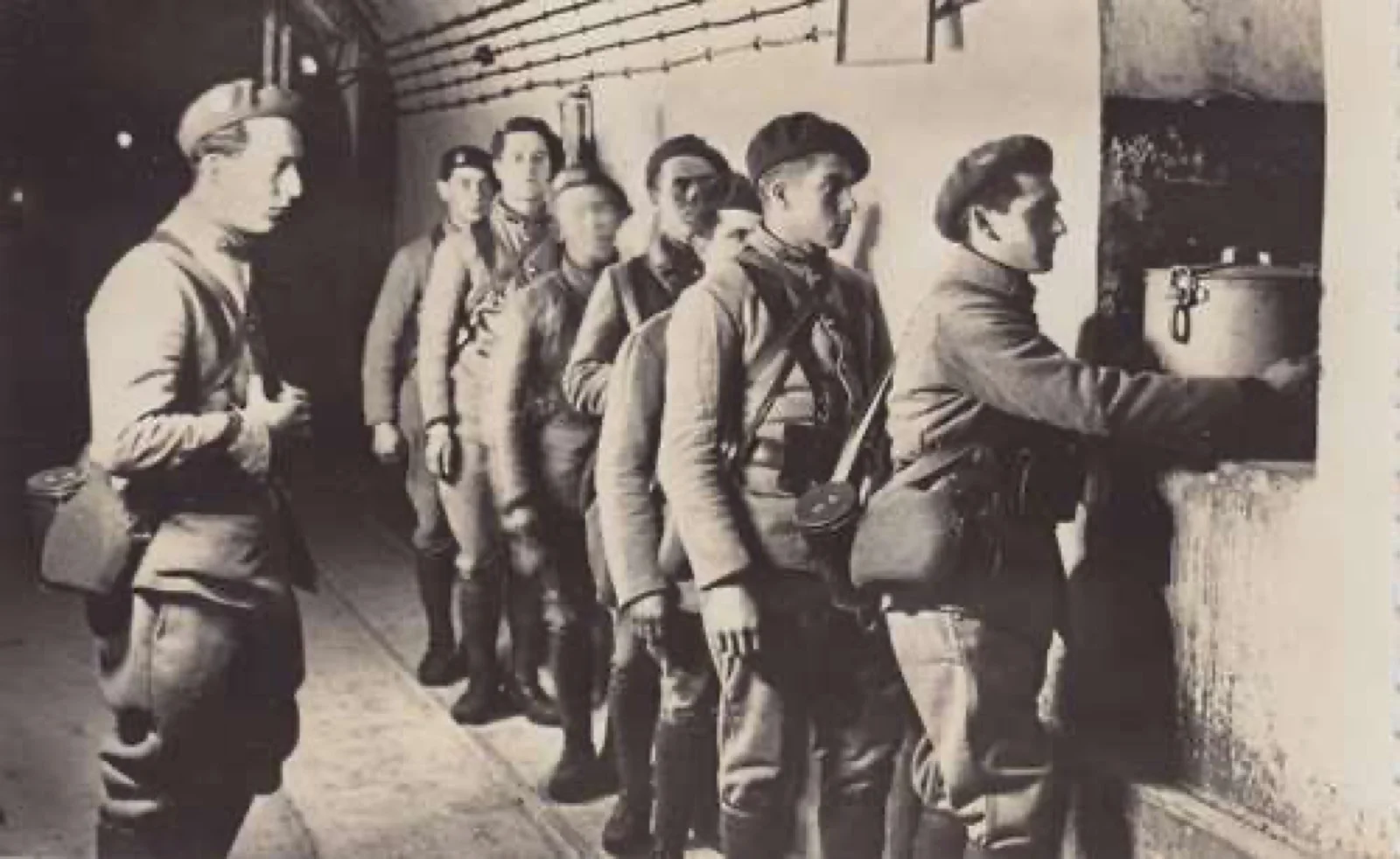 Une file de soldats français, gamelle à la main, attend la distribution de la soupe dans une galerie de la ligne Maginot, hiver 1939-1940.