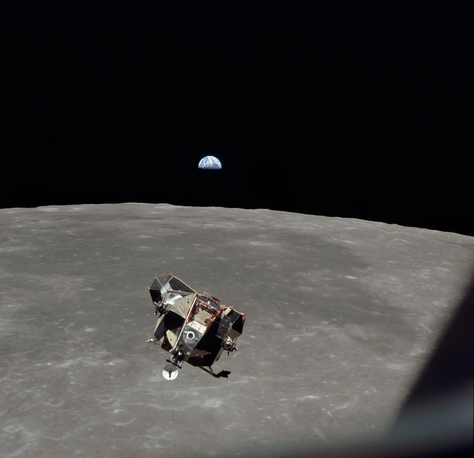 L'étage de remontée du module lunaire Eagle, Armstrong et Aldrin à bord, remonte vers Columbia au-dessus du limbe lunaire ; la Terre se lève à l'horizon, 21 juillet 1969.