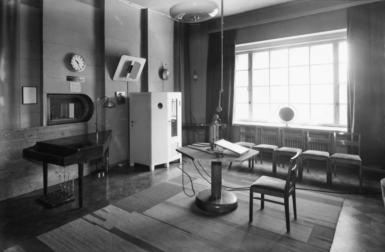 Studio de radiodiffusion des années 1940, table hexagonale à microphone au centre.
